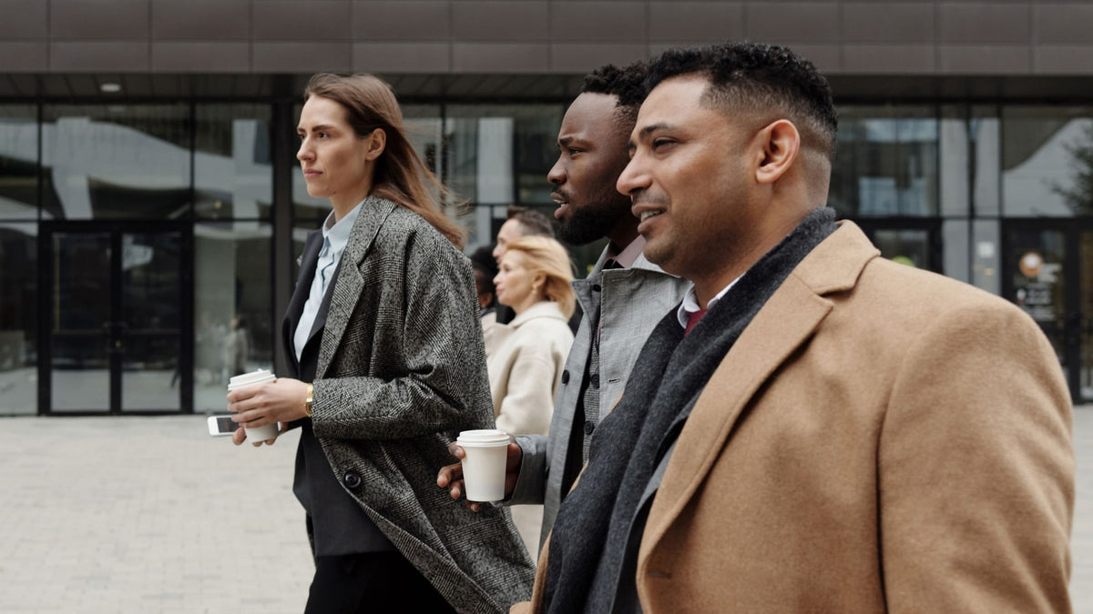 Colleagues walking outside with takeaway coffee cups