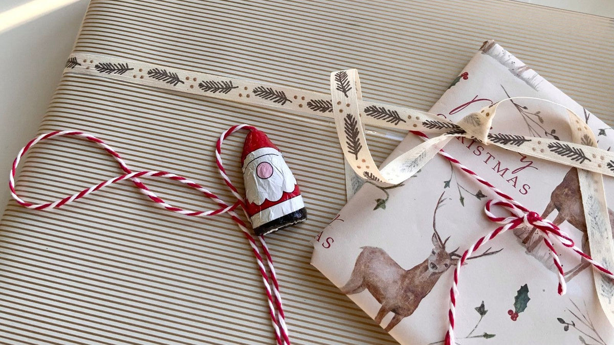 Christmas gifts wrapped in patterned paper with ribbon and red-and-white twine