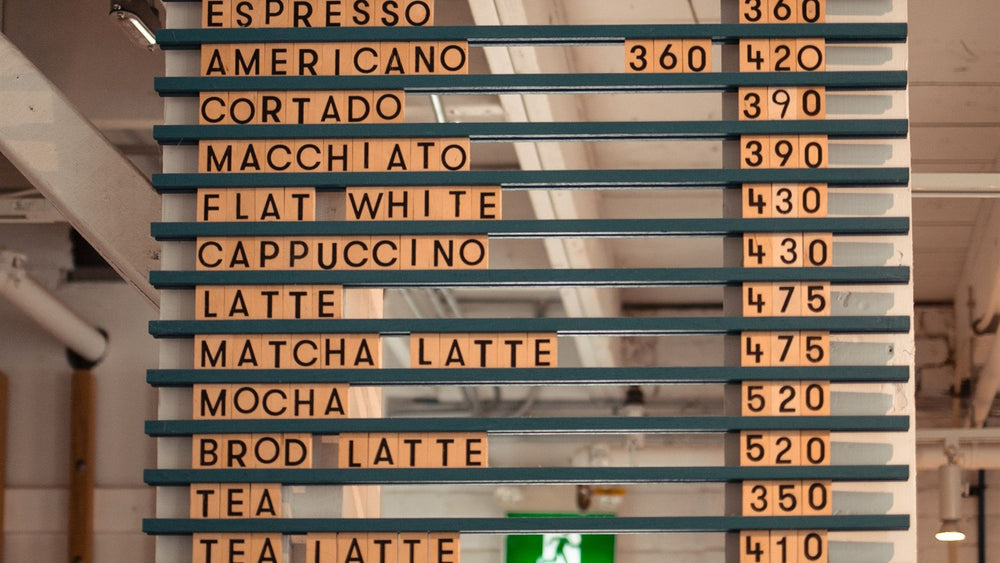Coffee shop menu board listing espresso drinks and prices