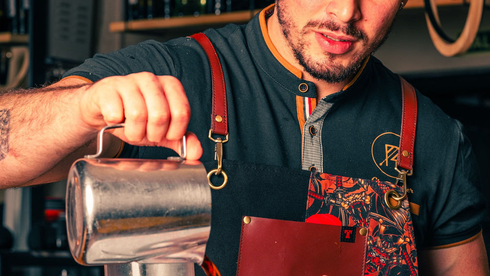 A barista brewing coffee with a glass siphon in a café