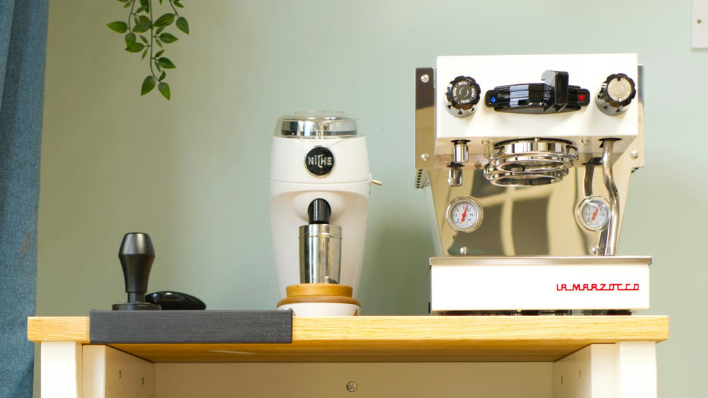 Compact home coffee station with an espresso machine and grinder on a narrow work surface