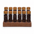 Solid walnut single-dose countertop coffee organizer with 12 glass tubes on white background