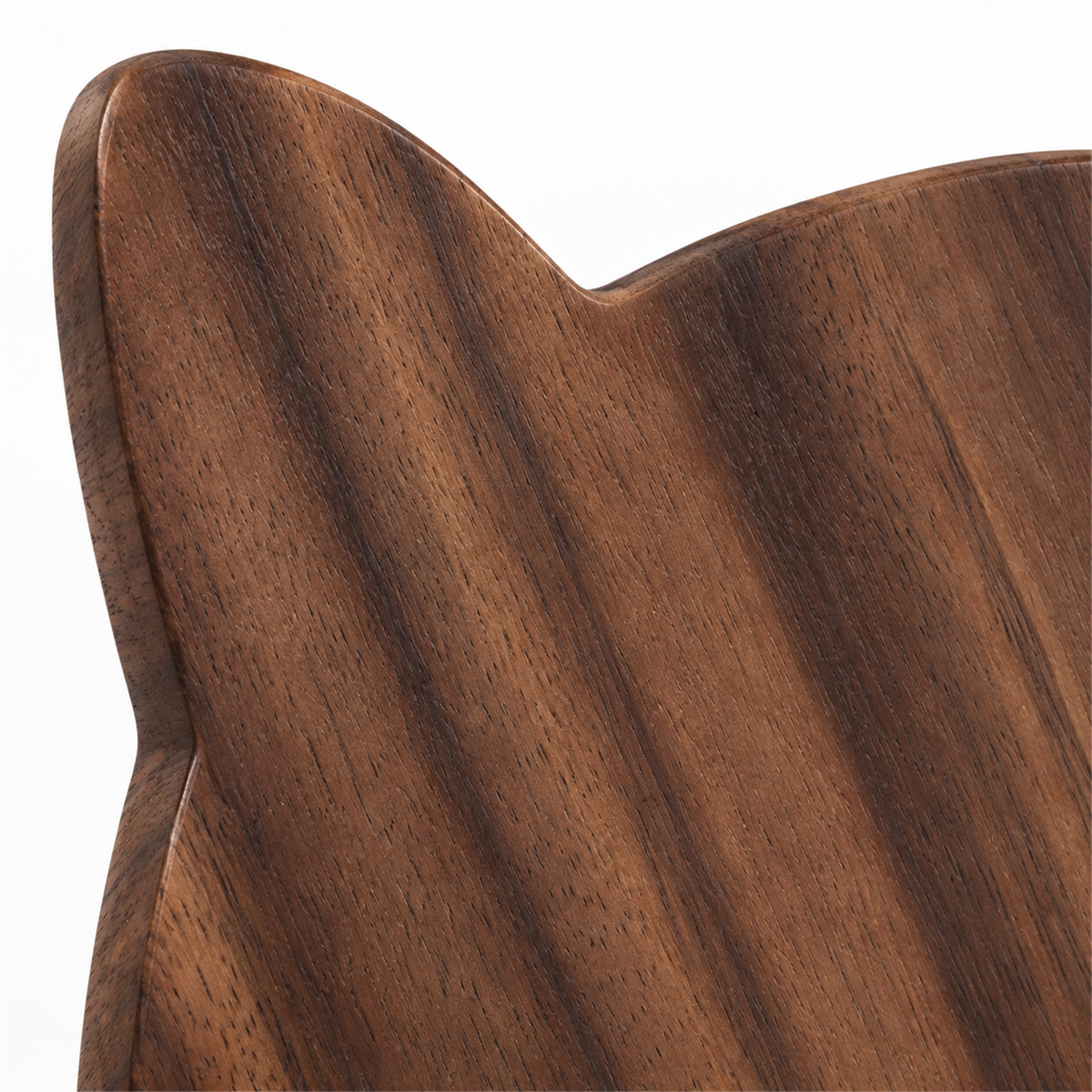 Close-up of natural walnut grain and rounded cat-ear silhouette