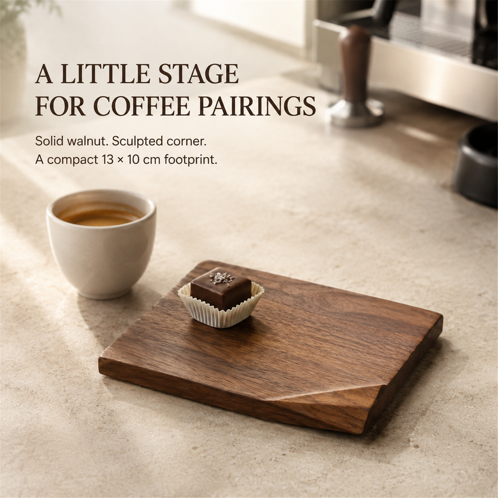 Solid walnut folded-corner dessert board with a chocolate petit four beside espresso, highlighting its sculpted corner and compact 13 by 10 cm footprint