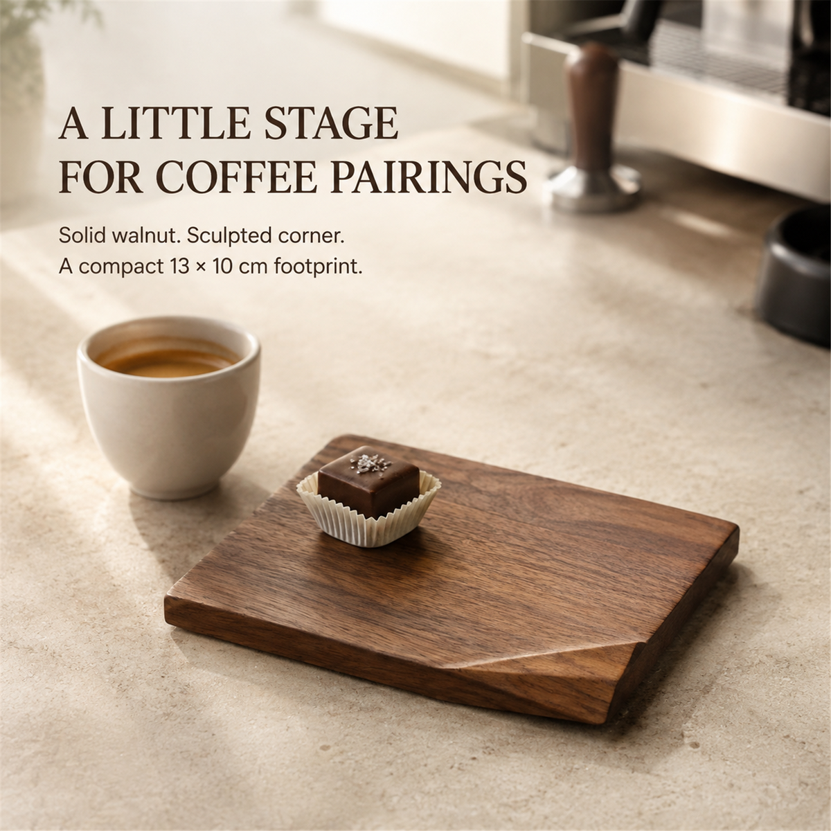 Solid walnut folded-corner dessert board with a chocolate petit four beside espresso, highlighting its sculpted corner and compact 13 by 10 cm footprint