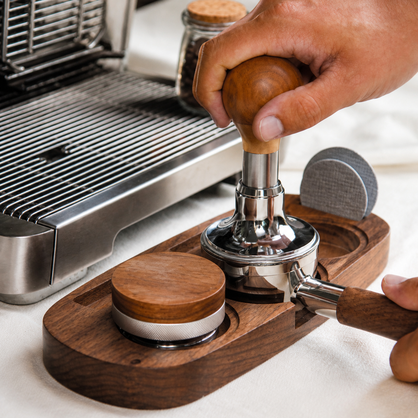 Espresso tamper, distributor and portafilter organized on a solid walnut tray