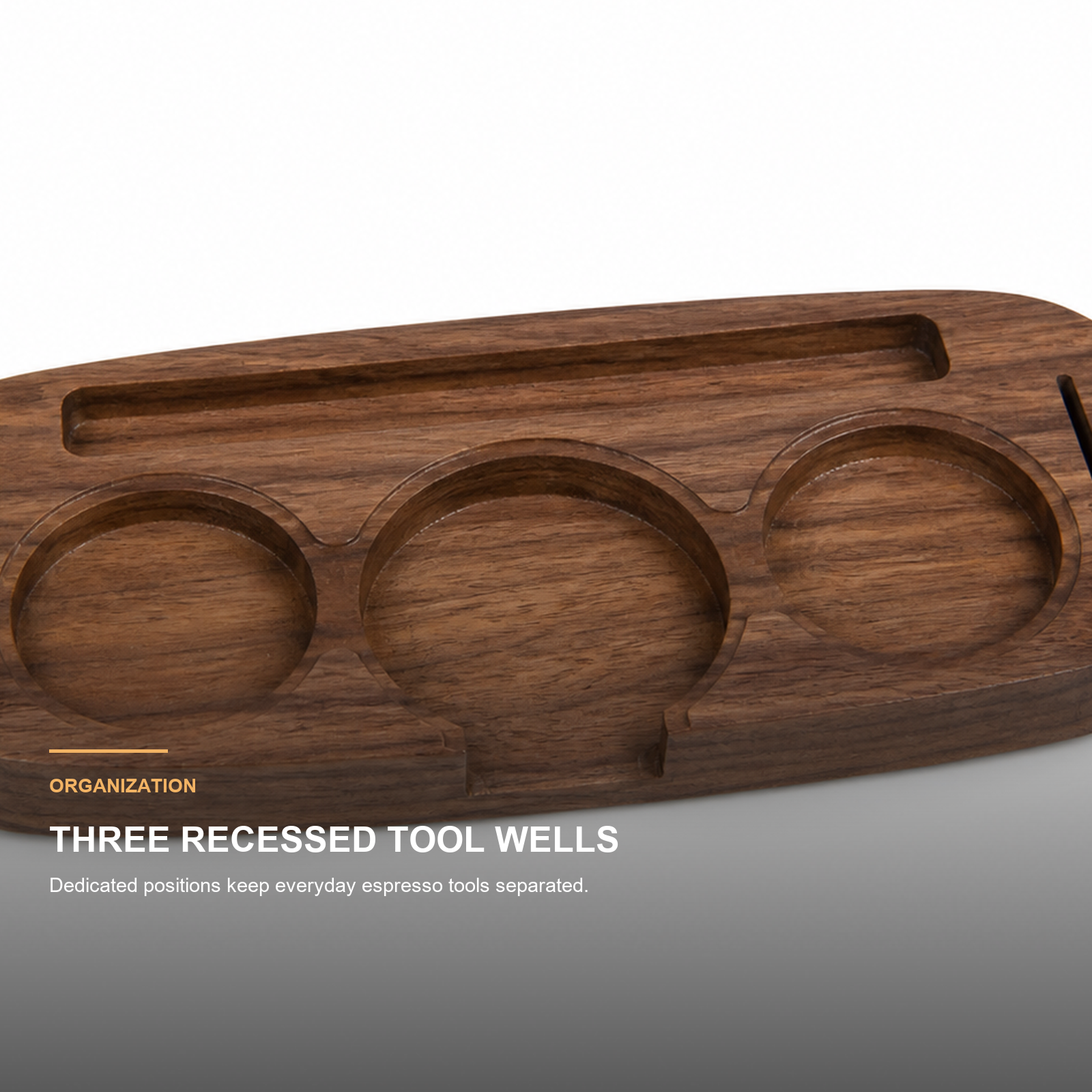 Close-up of three recessed espresso tool wells in solid walnut