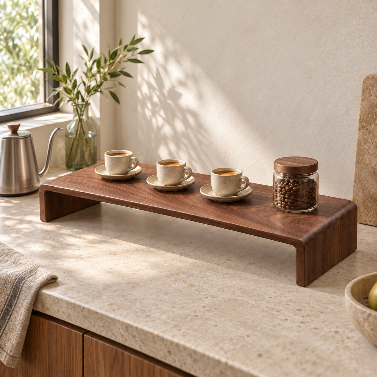 Walnut coffee riser displaying espresso cups and a small bean jar on a light kitchen counter