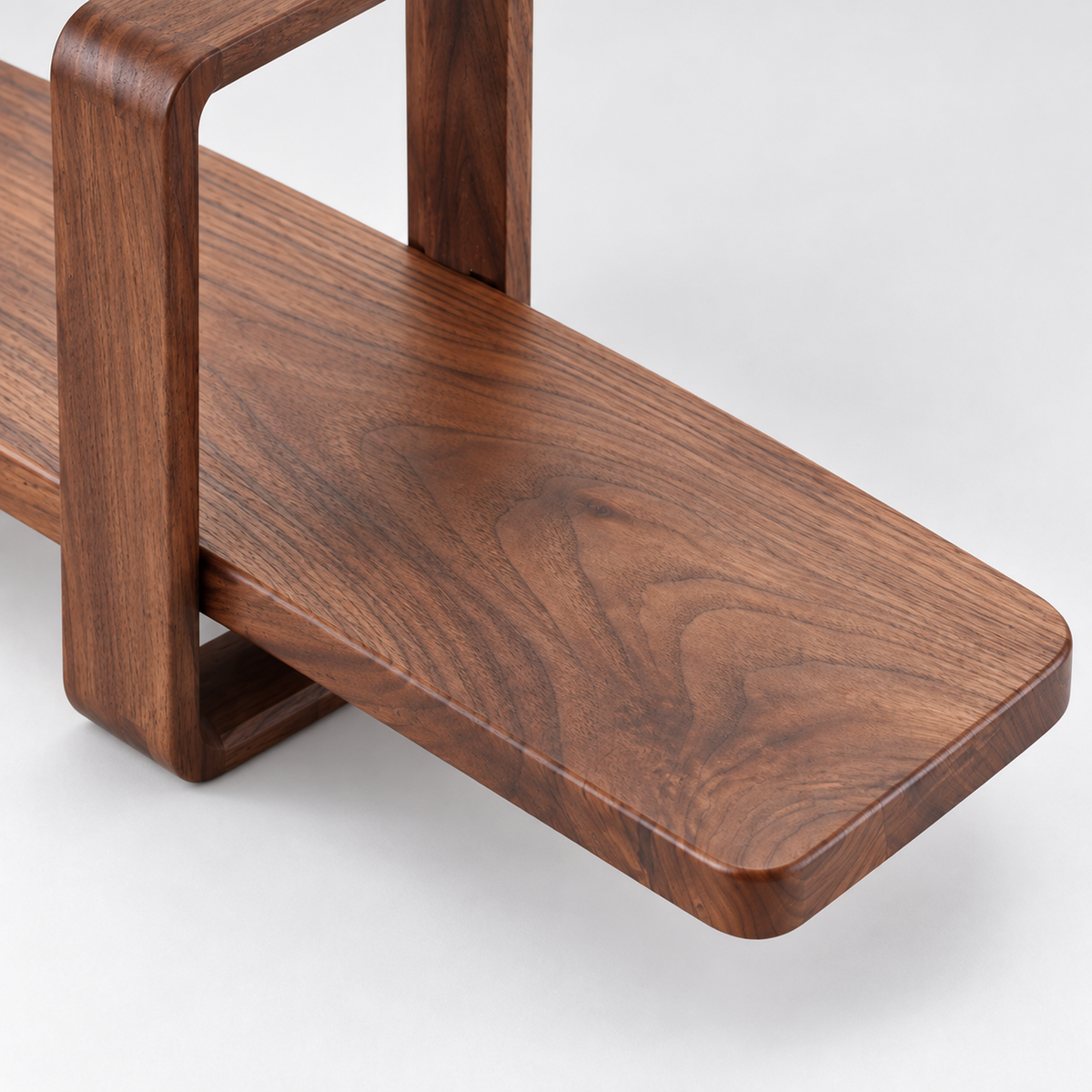 Detail of the walnut shelf board's rounded projecting end and natural grain