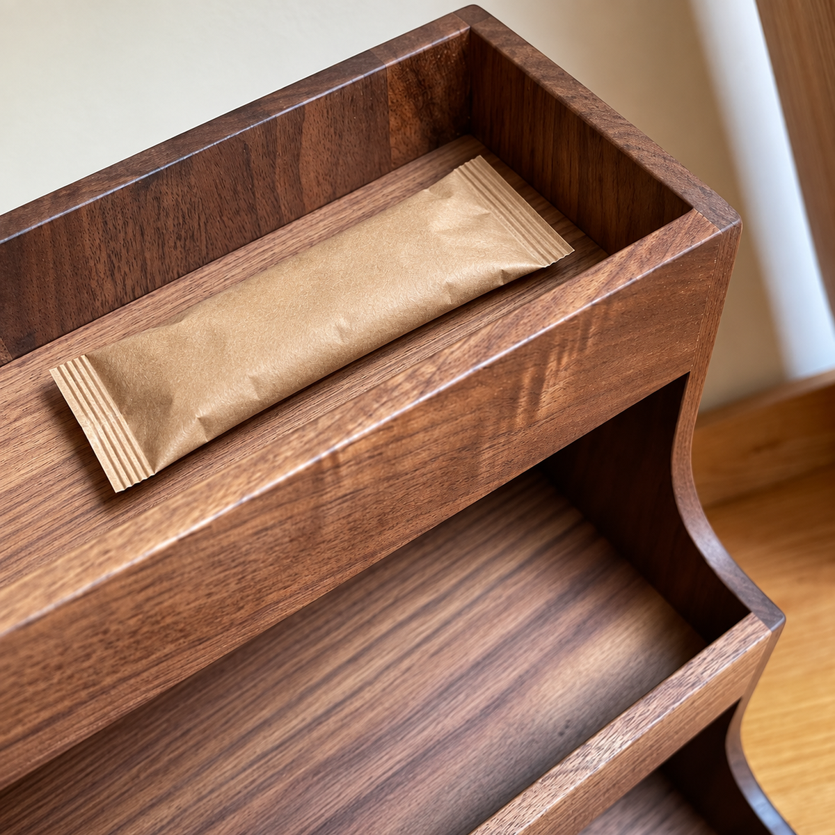 Shallow top tray showing walnut grain and a coffee sachet