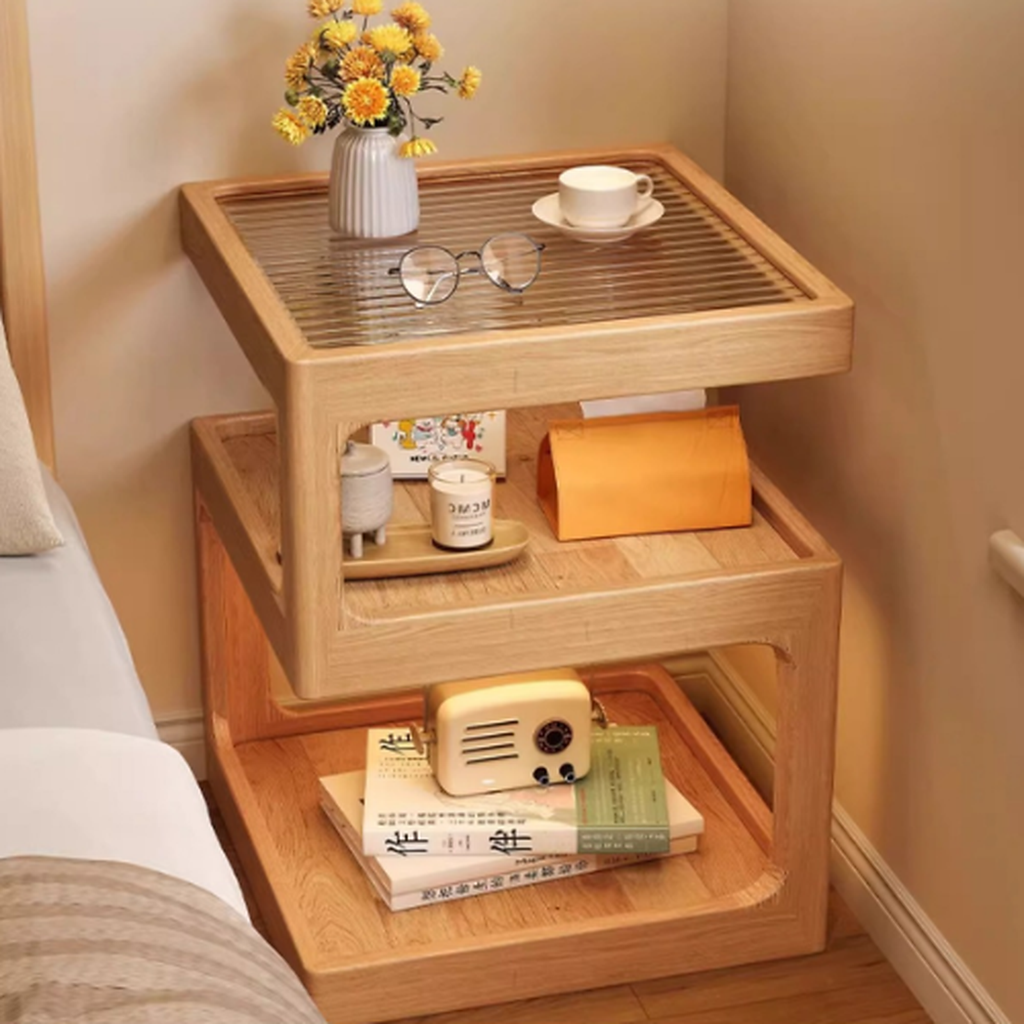 Natural finish three-tier coffee side table beside a bed with cups and small accessories